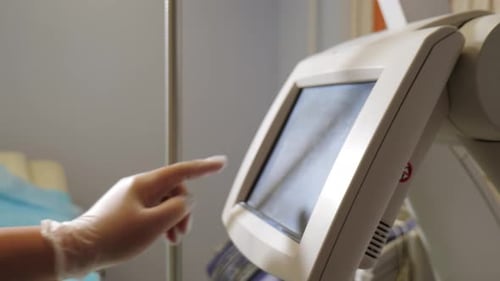 Gloved Hand Interacting With Touchscreen in Hospital