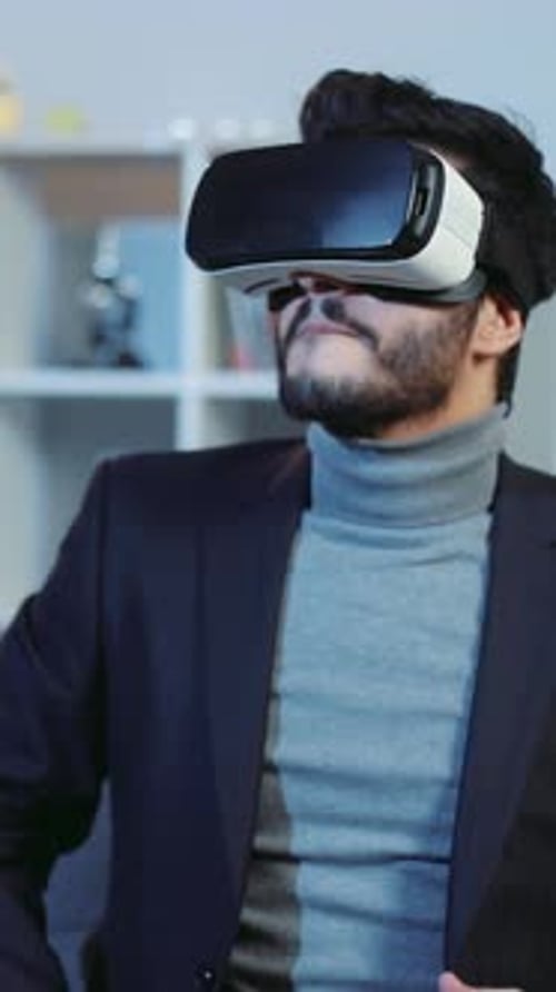 Мужчина, одетый в костюм, сейчас носит гарнитуру виртуальной реальности