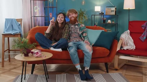 Affectionate Couple Relaxing Together on Orange Sofa