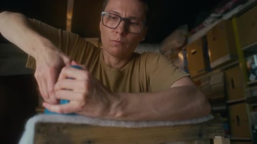 Woman Uses Staple Gun on Wooden Furniture