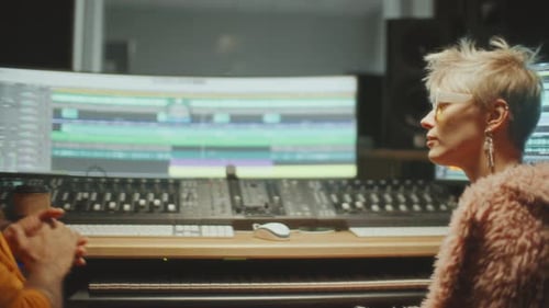 Female Music Artist and Sound Engineer Working on New Track in Recording Studio