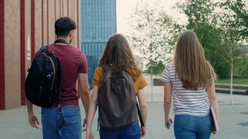 Three caucasian students walking through university campus. Shot with RED helium camera in 8K.