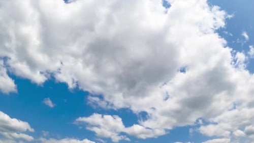Fluffy White Clouds Moving Across a Blue Sky