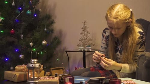 Child Crafting Christmas Cards by Decorated Tree
