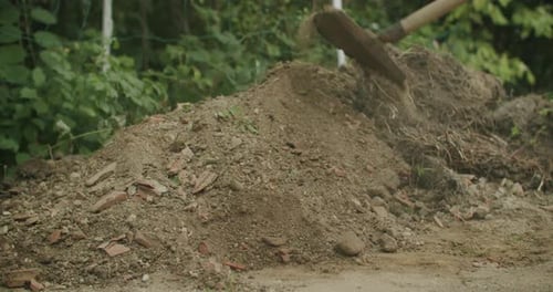 Shovel Moving Soil on Green Rural Land