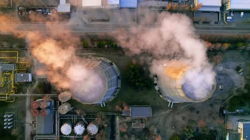 Aerial drone view of thermoelectric tower with white smoke in winter