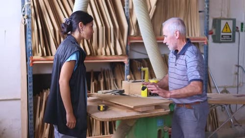 Woman and Man Discussing Woodworking Project in Workshop