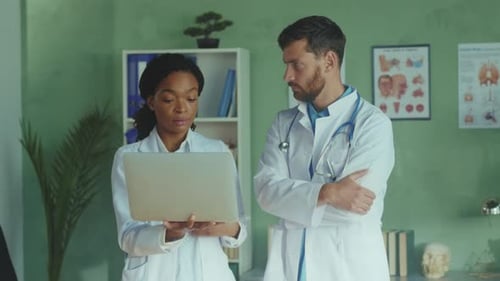 Doctors Reviewing Laptop in Office