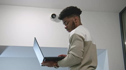 Young Adult Typing on Laptop Indoors
