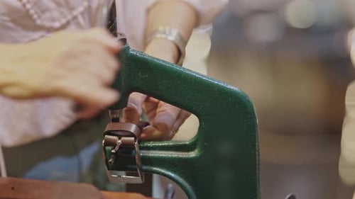 Une femme attache une boucle à une ceinture à l'aide d'une machine