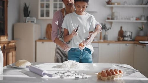 Mother and Daughter Making Dough for Cookies Putting Raw Eggs Into Flour Delicious Handmade Bakery