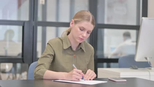 Young Businesswoman Writing a Letter in Office