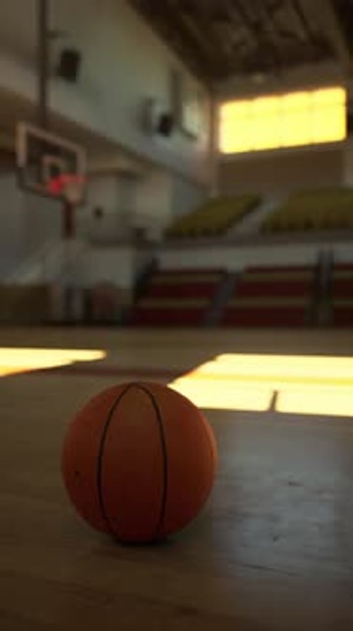 Basketball Resting on College Court Floor