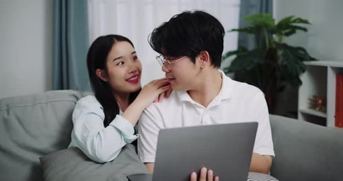 Smiling Couple Using Laptop Together at Home