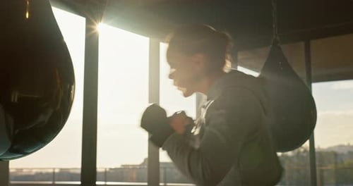 Woman Boxing With Speed Bag in Gym During Day