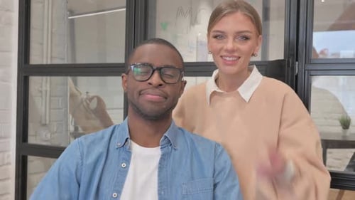 Man and Woman Giving Thumbs-Up in Office