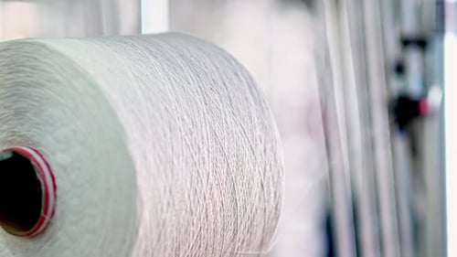 Manufacturing Spool of White Thread Spinning in Factory