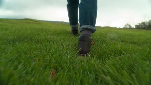 Leather Boots with Red Laces Walk on Green Field
