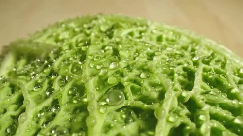Nasse grüne Salatblätter auf einem Holztisch, Sondenlinse mit Makro-Nahaufnahme