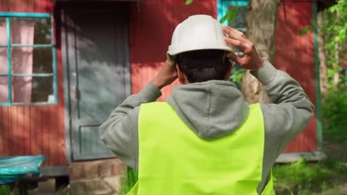 Worker Putting on a Hard Hat Outdoors