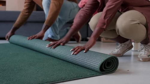 Wife and Husband Rolling Carpet before Relocation
