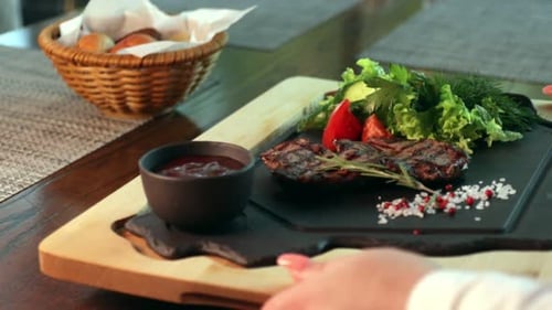 Steak on a Plate with Pepper Salt and Vegetables in the Restaurant