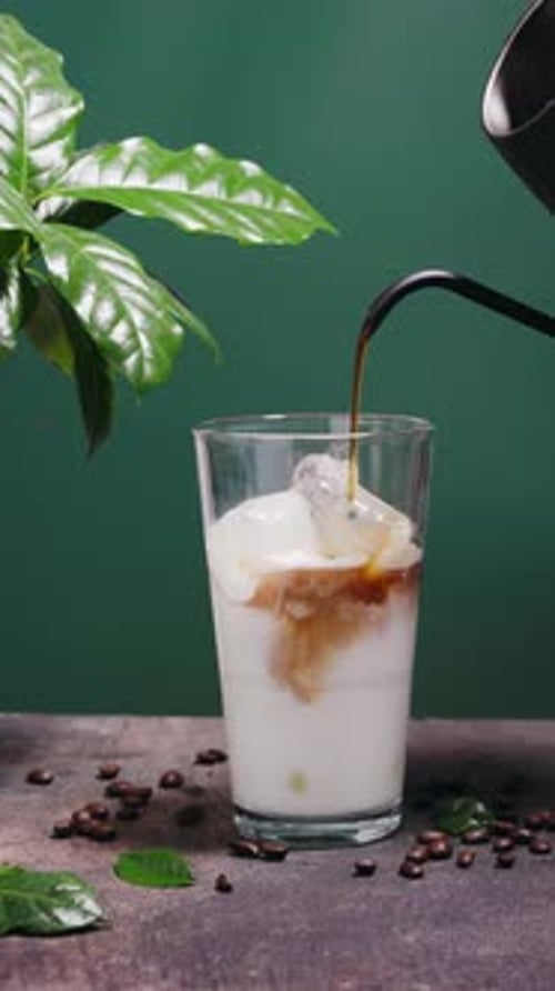 Delicious Iced Coffee in a Glass on Green Background