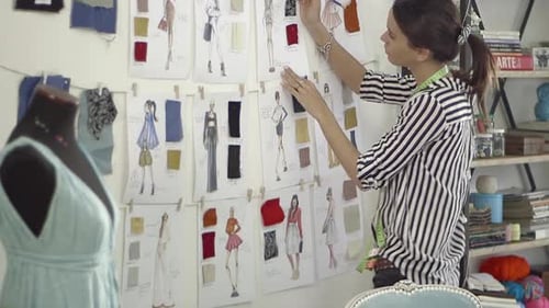 Young female fashion designer working at home studio.