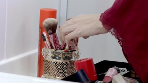 Woman Selects Makeup Brush from Collection