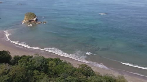 Aerial Overhead Shot With Pan Down Over Dense Trees Showing A Beautiful Tropical Beach