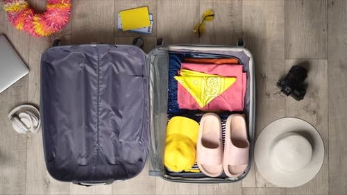 Stop Motion Animation Packing Suitcase With Colorful Clothes and Travel Accessories of Top View