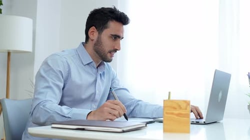 Young Adult Working at a Laptop in Office