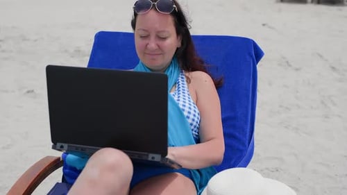 Smiling Freelancer Working on Laptop at Beach in Summer