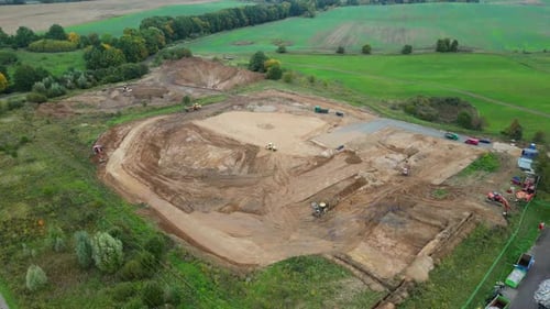 A drone flyover of a construction site, with visible construction and the building foundations being