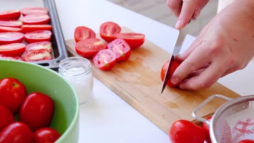 Close up view of man hands cutting tomatoes with a knife