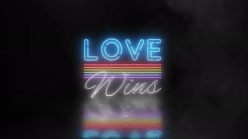 Love Wins Neonbotschaft mit Rauch und Reflexion auf dem Boden.