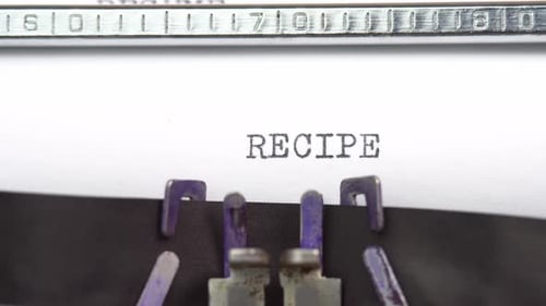 Recipe word closeup being typing and centered on a sheet of paper on old vintage typewriter