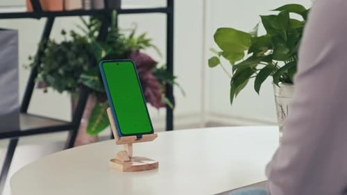 Woman Drinking in front of Smartphone and Swiping Green Chroma Key Screen