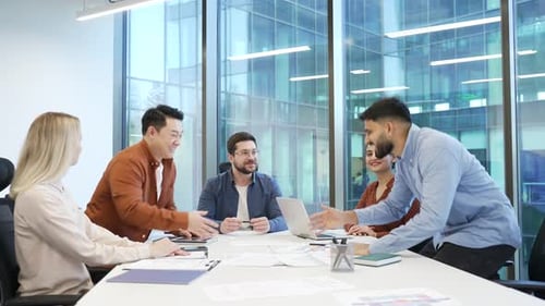 Business people shaking hands after deal at meeting sitting in modern office boardroom. Businessmen
