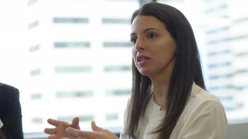 Empresaria hablando gesticulando en una reunión de oficina