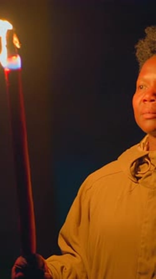 Young Adult Holding a Torch in the Dark