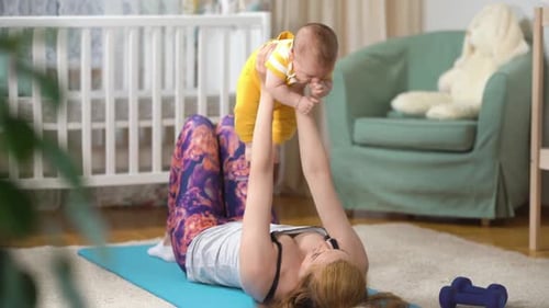 Mother Lifts Baby During Postnatal Fitness Exercise