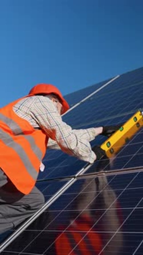 Technician Checking Solar Panel Angle with Spirit Level