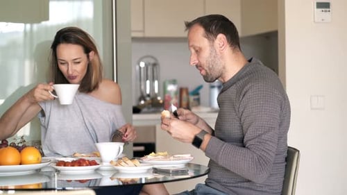 Couple Eating Breakfast Together at Home in Kitchen