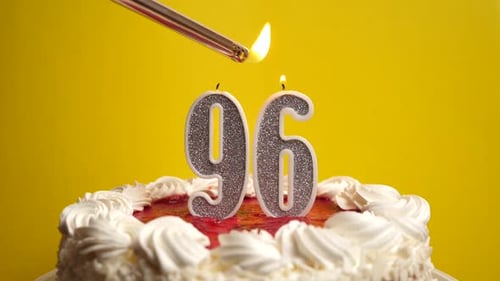 96. A candle in the form of the number 96, inserted into the holiday cake, is lit. Celebrating a bir