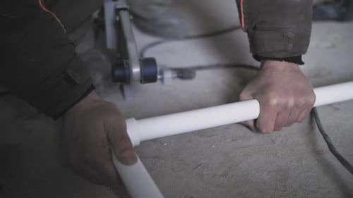 Plumber Connects White Pipes Together