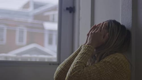 Woman Sitting on Floor With Face in Hands