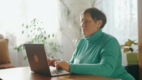 Senior Woman Typing on Laptop at Home