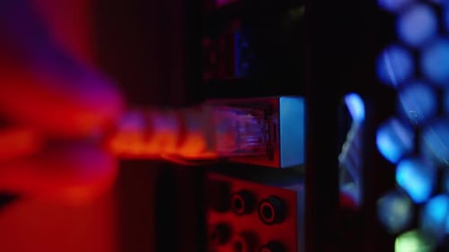 Connecting internet and local network to the Ethernet port of the computer. Close-up in blue light.