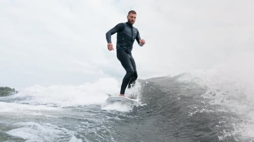 Surfer Skillfully Rides a Wave Showcasing Balance and Agility in Dynamic Ocean Scene